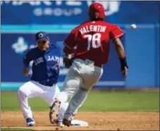  ?? NATHAN DENETTE — THE CANADIAN PRESS VIA AP ?? Phillies second baseman Jesmuel Valentin (76) steals second base before advancing to third when Toronto second baseman Ryan Goins, left, couldn’t handle the throw during the third inning in Dunedin, Fla., Thursday.