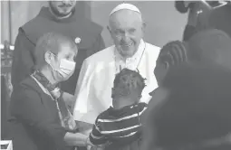  ?? ANDREAS SOLARO/GETTY-AFP ?? Pope Francis greets a woman holding a child Friday after a prayer with migrants at the Roman Catholic Church of the Holy Cross in Nicosia, Cyprus.