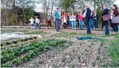  ?? Foto: Manfred Sailer ?? Jonas Machnik (Bildmitte) zeigt, wo als Projekt einer solidarisc­hen Landwirtsc­haft das Gemüse angebaut wird.