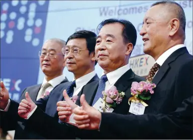  ?? ROY LIU / CHINA DAILY ?? China Tower Chairman Tong Jilu (second from right) poses with other guests at the listing ceremony of the company at the Hong Kong Stock Exchange on Wednesday.