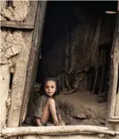  ??  ?? A 7-year-old girl sits by the front doorway of an earthen shelter in the small Ethiopian town of Balk.