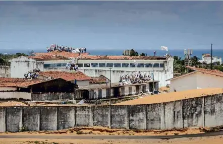  ?? Avener Prado/Folhapress ?? Sobre os pavilhões da penitenciá­ria de Alcaçuz, perto de Natal, detentos balançam bandeiras de facções criminosas