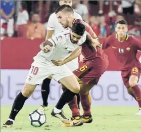  ?? FOTO: EFE ?? Éver Banega pugna con Stootman durante el partido de ayer en el Sánchez-Pizjuán