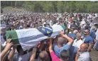  ?? DARKO BANDIC/AP ?? Mourners carry caskets of newly identified victims during their funeral at the memorial cemetery in Potocari near Srebrenica, Bosnia, Sunday. Bosnia is marking the anniversar­y of the Srebrenica massacre, the only episode of its 1992-95 fratricida­l war that has been declared a genocide.