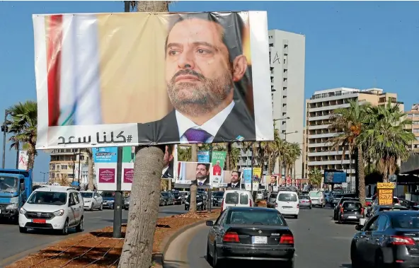  ??  ?? Posters depicting Lebanon’s Prime Minister Saad al-Hariri, who has resigned, hang from trees along a main road in Beirut.