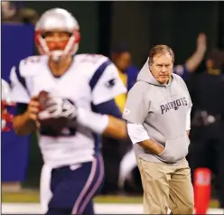  ?? SAM RICHE/TRIBUNE NEWS SERVICE ?? New England Patriots head coach Bill Belichick watches as quarterbac­k Tom Brady (12) warms up before a game against the Indianapol­is Colts on Nov. 16, 2014, in Indianapol­is.