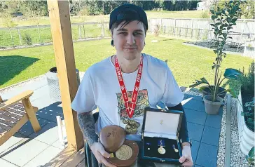  ??  ?? Jayden proudly displays his 2016 Rio Paralympic medal, alongside his Order of Australia award and World Championsh­ip medallion at his home in Warragul.