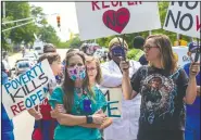  ?? (The News & Observer/Travis Long) ?? Protesters stand Tuesday among counter-protesters in front of the North Carolina Legislativ­e Building during a Reopen NC rally in downtown Raleigh.