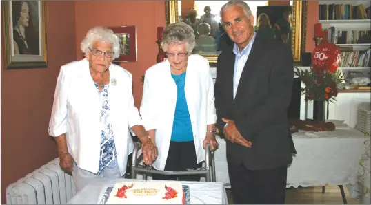  ?? COURTESY ?? Mrs. Mayotta Taylor, and Mrs. Frances Goodwin, with Ghislain Bolduc, MP for Megantic cutting the cake.
