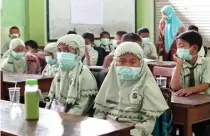  ?? CHUSNUL CAHYADI/JAWA POS ?? SIGAP: Siswa MI Futuhatul Ulum berada di ruang kelas sambil mengenakan masker dalam simulasi bencana kegagalan teknologi kemarin.