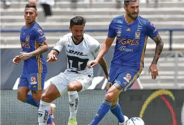  ?? Rodrigo Arangua / AFP/Getty Images ?? André-Pierre Gignac (der.), de Tigres, controla el balón ante la marca de Idekel Domínguez, de Pumas, en el partido disputado el domingo 4 de agosto de 2019 en la ciudad de México por el torneo Apertura.