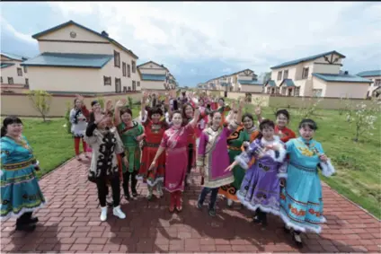  ??  ?? People in Bacha, a village in Heilongjia­ng Province in northeast China, take photos with their new houses in the background on May 25, 2016