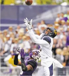  ?? Elaine Thompson / Associated Press ?? Cal’s Darius White leaps above Washington’s Marvin Hall to intercept a pass during the first half Saturday in Seattle.