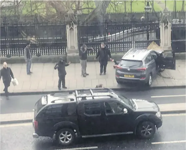  ?? JAMES WEST / AFP / GETTY IMAGES ?? A video grab from the Twitter account of James West shows a car stopped on the sidewalk in front of the Houses of Parliament in central London on Wednesday, after a group of pedestrian­s were run down and an officer was stabbed in what police called...