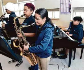  ?? Arnold Gold/Hearst Connecticu­t Media ?? From left, sixth graders Jeremiah Hicks, Arianna Melndez and Lizmarie Gragirene on the sax and Israel Machicote on the piano play during a practice session between classes at John S. Martinez Magnet School in New Haven on Friday.