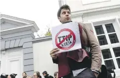  ?? EMMANUEL DUNAND / AFP / GETTY IMAGES ?? A man holds a poster reading ‘Stop TTIP — Stop CETA.’