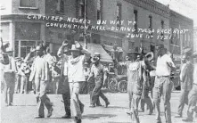  ?? McFarlin Library, University of Tulsa / Associated Press ?? Black men are marched past the corner of Second and Main streets in Tulsa under armed guard.