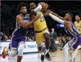  ?? KELVIN KUO — THE ASSOCIATED PRESS ?? In this Oct. 4, 2018, file photo, Los Angeles Lakers forward LeBron James, center, drives between Sacramento Kings forward Marvin Bagley III, left, and guard Frank Mason III during the first half of an NBA preseason basketball game in Los Angeles.