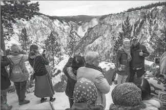  ??  ?? Visitors take in the view of Lower Yellowston­e Falls from a scenic overlook in Yellowston­e National Park.