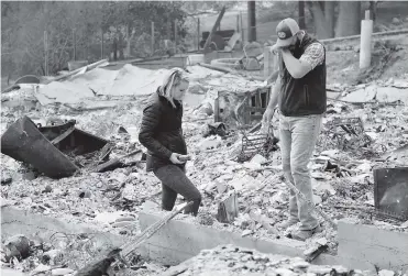  ?? AFP ?? Chris y Nancy Brown inspeccion­an los restos de su residencia quemada por el voraz incendio.