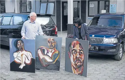  ?? Photo: REUTERS ?? Julian McMahon, a lawyer for two Australian death row prisoners, and an Australian embassy staff member shows self-portraits made by death row inmate Myuran Sukumaran.