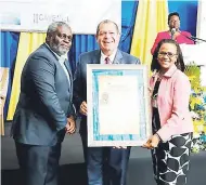  ??  ?? Former Financial Secretary in the Ministry of Finance and the Public Service, Devon Rowe (left), displays the Management Institute for National Developmen­t (MIND) Public Life Award for Leadership Excellence for 2017. Sharing in the occasion are...