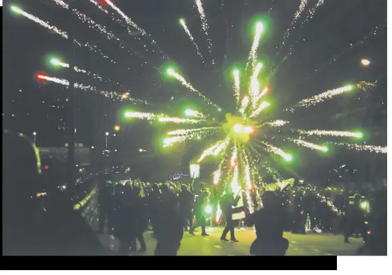  ?? ?? right Fireworks lit by protesters at a rally in Din Daeng district.