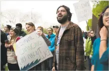  ?? MADDIE MCGARVEY/THE NEW YORK TIMES ?? James Sutter, an environmen­tal science teacher at Wellston High School, attends the March for Science with three students April 22 in Athens, Ohio. As more of the nation’s teachers seek to integrate climate science into the curriculum, many of them are...