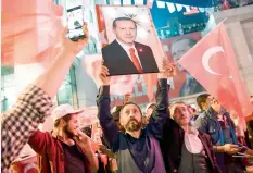  ?? — AFP ?? A supporter of the “yes” camp brandishes a picture of Turkish president Recep Tayyip Erdogan during a rally in Istanbul after the results