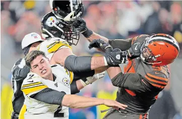  ?? DAVID RICHARD THE ASSOCIATED PRESS ?? Cleveland Browns defensive end Myles Garrett (95) hits Pittsburgh Steelers quarterbac­k Mason Rudolph (2) with a helmet during the second half of an NFL football game Thursday in Cleveland.