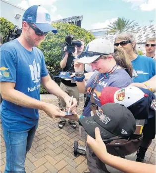  ?? STEPHEN M. DOWELL/STAFF PHOTOGRAPH­ER ?? Dale Earnhardt Jr., voted most popular NASCAR driver for 14 straight years, signs autographs for fans at Daytona Internatio­nal Speedway on Friday. He also won the pole Friday for tonight’s race.