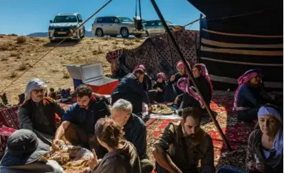  ?? IMAN AL-DABBAGH/NEW YORK TIMES ?? A Bedouin family hosted a Christian tour group for lunch in Saudi Arabia’s Tabuk region.