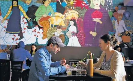  ?? Photos by Paul Chinn / The Chronicle ?? Ben and Nikki Luna, above, have lunch at the Temple Club in Oakland. Left: Brown fried rice with cucumbers and topped with an egg.