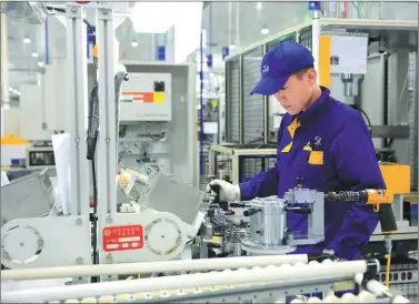  ?? PHOTOS PROVIDED TO CHINA DAILY ?? A technician with Shengrui Transmissi­on examines a front-drive eight-gears auto transmissi­on unit produced by the company. Located in the Weifang Hi-tech Industrial Developmen­t Zone, the company is a winner of the National Science and Technology...