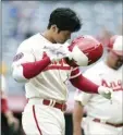  ?? AP photo ?? Shohei Ohtani takes off his helmet after popping out to end the Angels’ 8-7 loss to the A’s on Thursday. Ohtani hit two of Los Angeles’ record-tying seven solo home runs in the game.