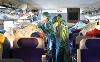  ?? — AFP photo ?? French nurses take care of four patients infected with the novel coronaviru­s (Covid-19) in a medicalise­d TGV (highspeed train) at Nancy train station as 24 patients from Nancy and Metz are being transfered from Nancy and Metz towards Bordeaux, Libourne, Pau and Bayonne.