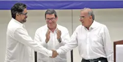  ?? PICTURE: EPA ?? AGREED: Second-in-command of the Revolution­ary Armed Forces of Colombia (FARC) Iván Márquez, left, shakes hands with the Colombian government’s chief peace negotiator, Humberto de la Calle, as Cuban foreign minister Bruno Rodriguez claps in Havana,...