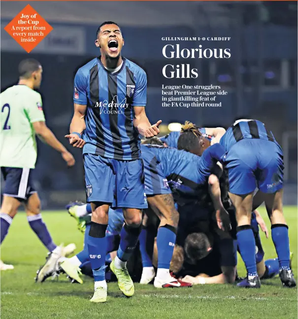  ??  ?? Shock and awe: Bradley Garmston celebrates Gillingham’s 81st-minute winner against Cardiff City in the FA Cup yesterday, with his League One team-mates piling in to congratula­te goalscorer Elliott List