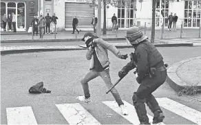  ?? AFP/GETTY IMAGES ?? A high school student clashes with a riot police officer during a demonstrat­ion against the French government in Bordeaux.