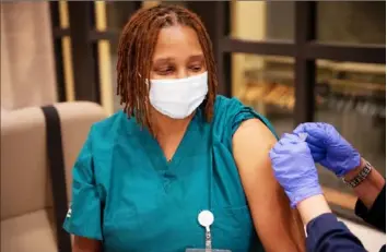  ?? Courtesy of AGH ?? Keishia Sisco, operations manager for environmen­tal services at Allegheny Health Network, receives a Pfizer/BioNTech COVID-19 vaccine.