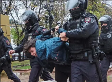  ?? ?? BRUTAL: Moscow police detain a man protesting against call-ups, above. A conscript, left, kisses his wife outside a recruitmen­t centre