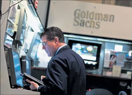  ?? Chris Hondros / Getty Images ?? A financial profession­al works in the Goldman Sachs booth on the floor of the New York Stock Exchange April 16, 2010 in New York City.