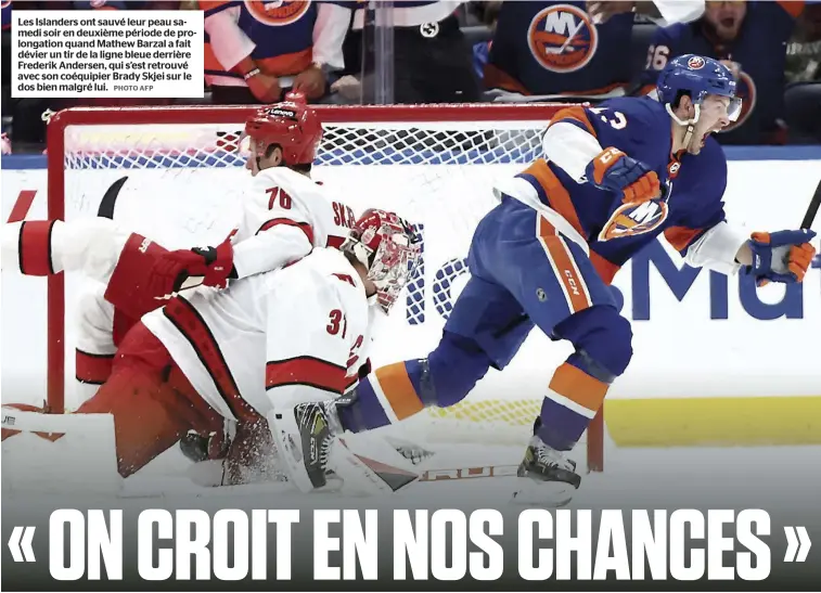  ?? PHOTO AFP ?? Les Islanders ont sauvé leur peau samedi soir en deuxième période de prolongati­on quand Mathew Barzal a fait dévier un tir de la ligne bleue derrière Frederik Andersen, qui s’est retrouvé avec son coéquipier Brady Skjei sur le dos bien malgré lui.