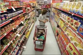  ?? (AP Photo/Tony Gutierrez, File) ?? FILE - In this Dec. 14, 2010, file photo, Alicia Ortiz shops through the cereal aisle as her daughter Aaliyah Garcia catches a short nap in the shopping cart at a Family Dollar store in Waco, Texas. Don’t be intimidate­d by the idea of a weekly big supermarke­t shop. Buying a lot in one fell swoop helps keep your kitchen organized and well-stocked all week.