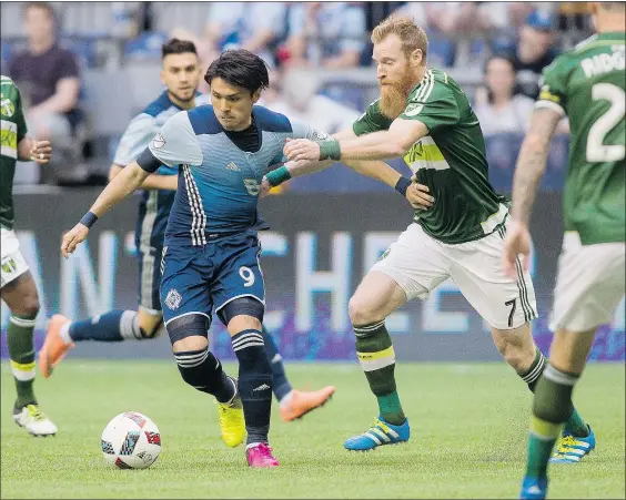  ?? — THE CANADIAN PRESS ?? Vancouver’s Masato Kudo plays the ball against Portland’s Nat Borchers during first half MLS action in Vancouver on Saturday. The Whitecaps were rewarded for carrying the play and creating numerous quality scoring chances.