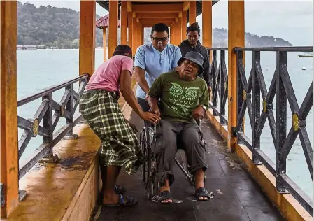  ?? — bernama ?? Island medicine: Hasrul yadidi pushing a patient on a wheelchair who fell ill after returning from sea at Kampung Pulau Perhentian.