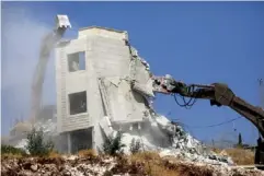  ?? (EPA) ?? An Israeli army excavator demolishes a building in Sur Baher