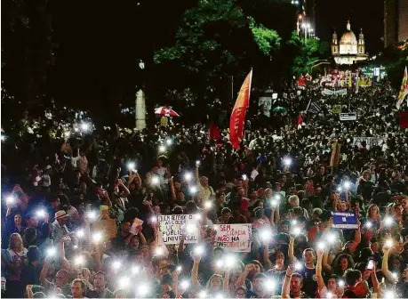  ?? Pilar Olivares/Reuters ?? Manifestan­tes com celulares acesos em ato no Rio contra o bloqueio de verba na educação