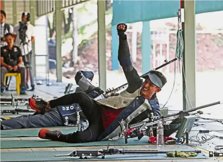  ??  ?? Hit the jackpot: Malaysia’s Muhd Ezuan Nasir Khan celebratin­g after clinching the gold medal in the 50m rifle prone event at the National Shooting Range Centre in Subang yesterday.