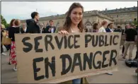  ?? (AP/Nicolas Garriga) ?? A woman holds a poster reading “Public service in danger” as diplomats strike near the French Foreign Ministry on Thursday in Paris.